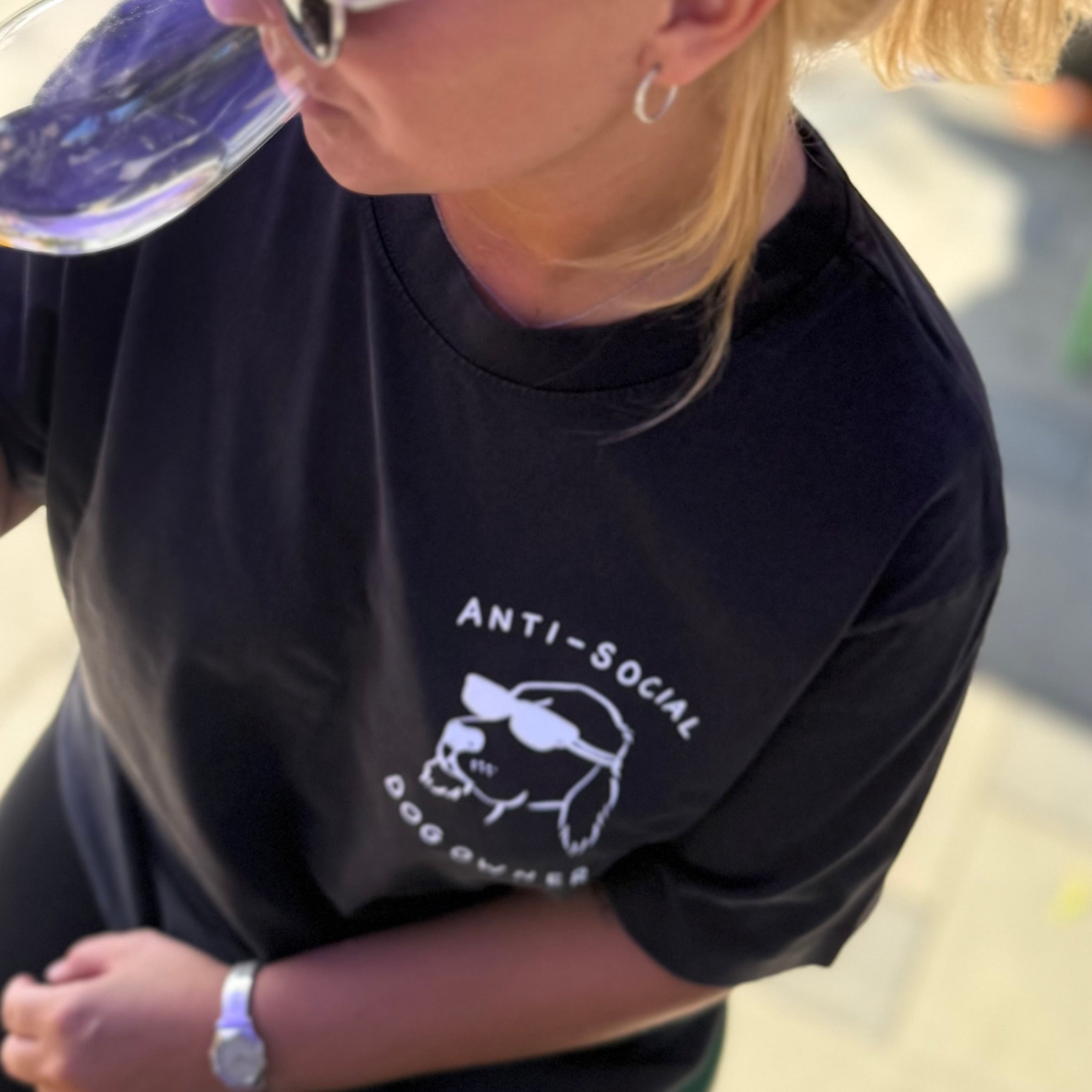 Person wearing a black t-shirt with 'ANTI-SOCIAL DOG OWNERS' text and graphic.