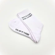 Folded white tube socks on white background with small text ANTI-SOCIAL DOG OWNER.