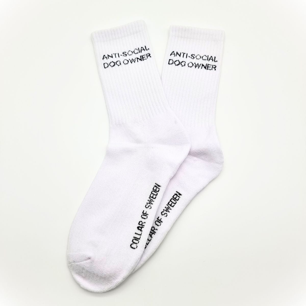 White tube socks on white background with small text ANTI-SOCIAL DOG OWNER.